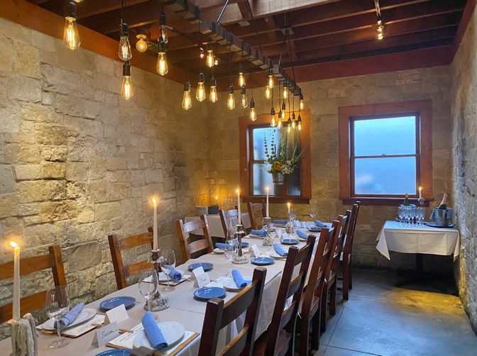 Intimate private event at Sufigrill with rustic stone walls and elegant table setting.