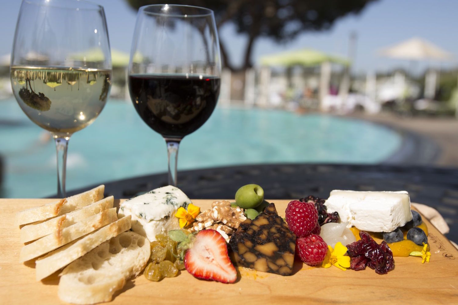 Elegant outdoor networking event at Firefly Eatery with charcuterie board and poolside ambiance.