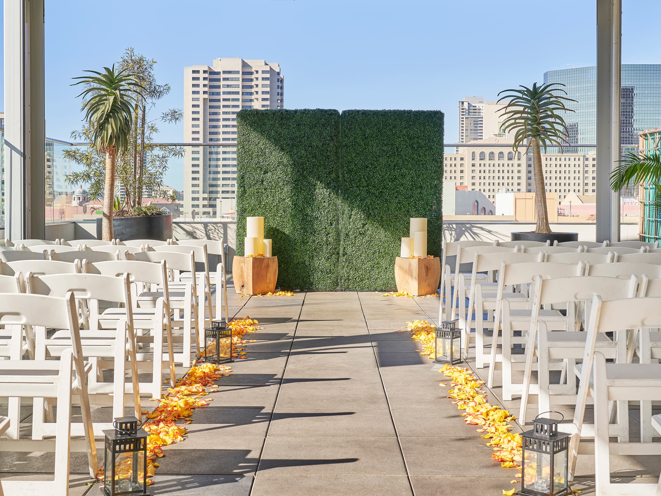 Outdoor wedding ceremony setup in San Diego with white chairs and scattered petals.