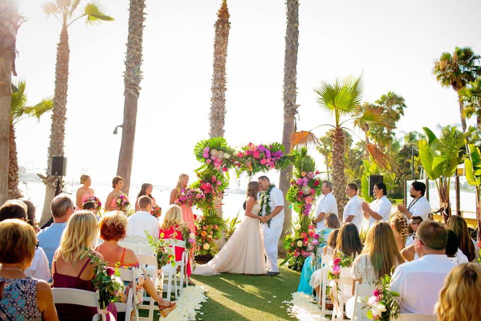 Outdoor wedding ceremony in San Diego with floral arch and ocean views.