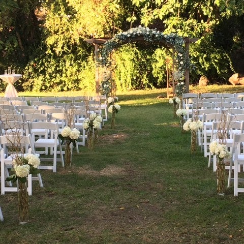 Ballroom at Swiss Park: elegant floral arch for outdoor wedding ceremony.
