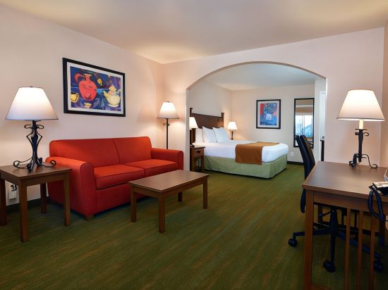 Cozy hotel room with vibrant sofa, ideal for business meetings and events.