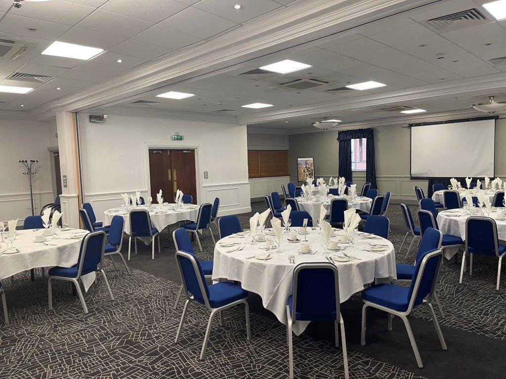 Prince of Wales at Mercure Birmingham: elegant event space with round tables and projector.