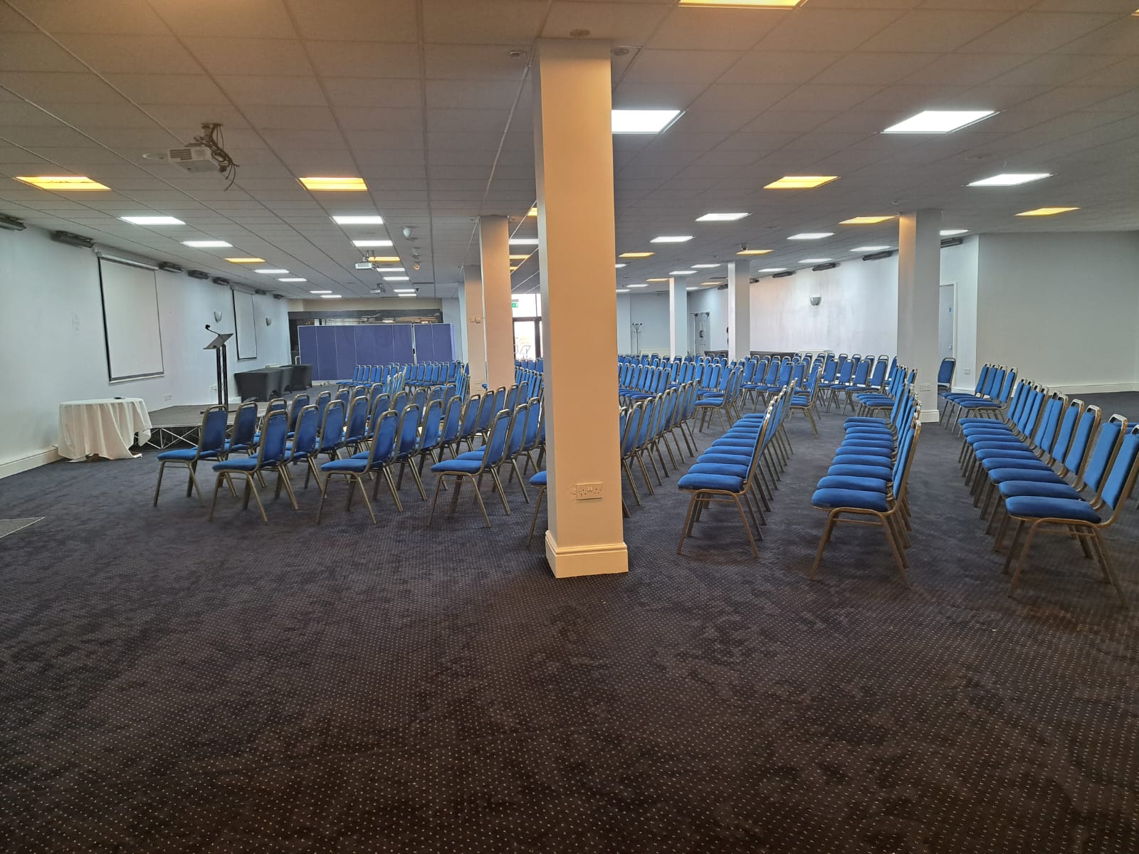 Saffron Suite conference room with blue chairs, ideal for presentations and workshops.