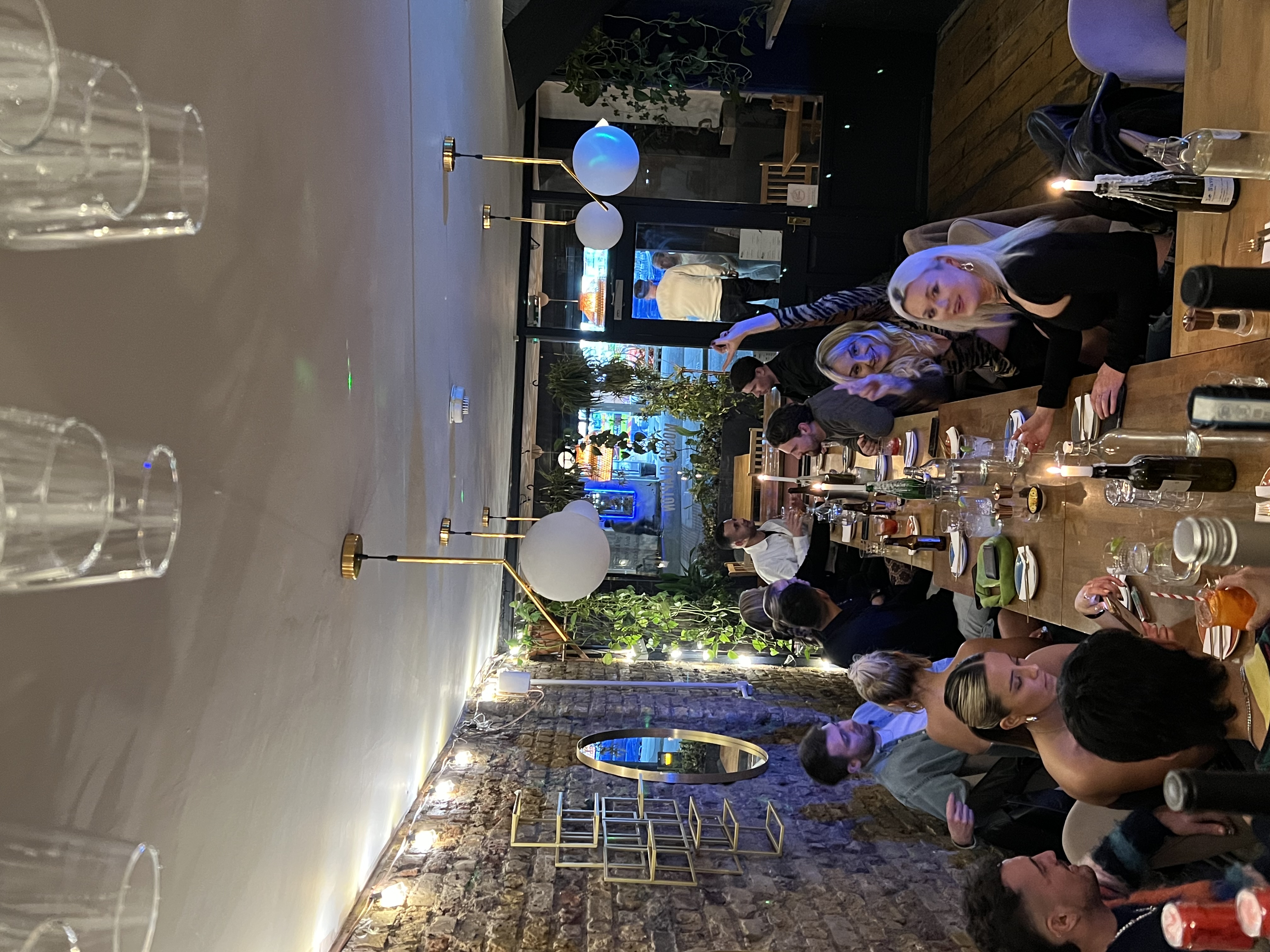 Lively dinner gathering at Mosaic Clapton Wine Bar with warm lighting, perfect for networking.