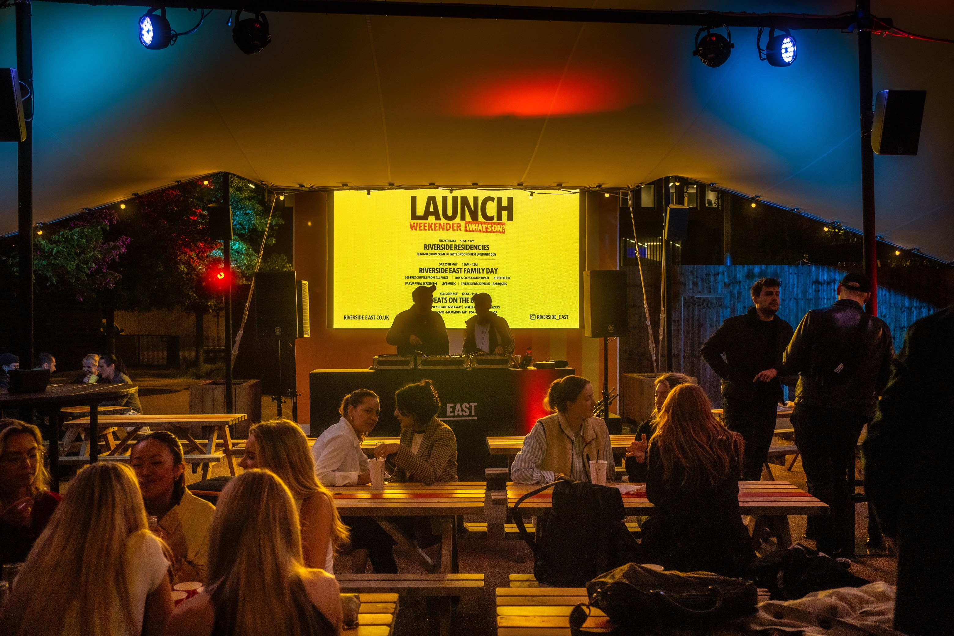 Vibrant outdoor product launch at The Yard, featuring colorful lighting and a stage.