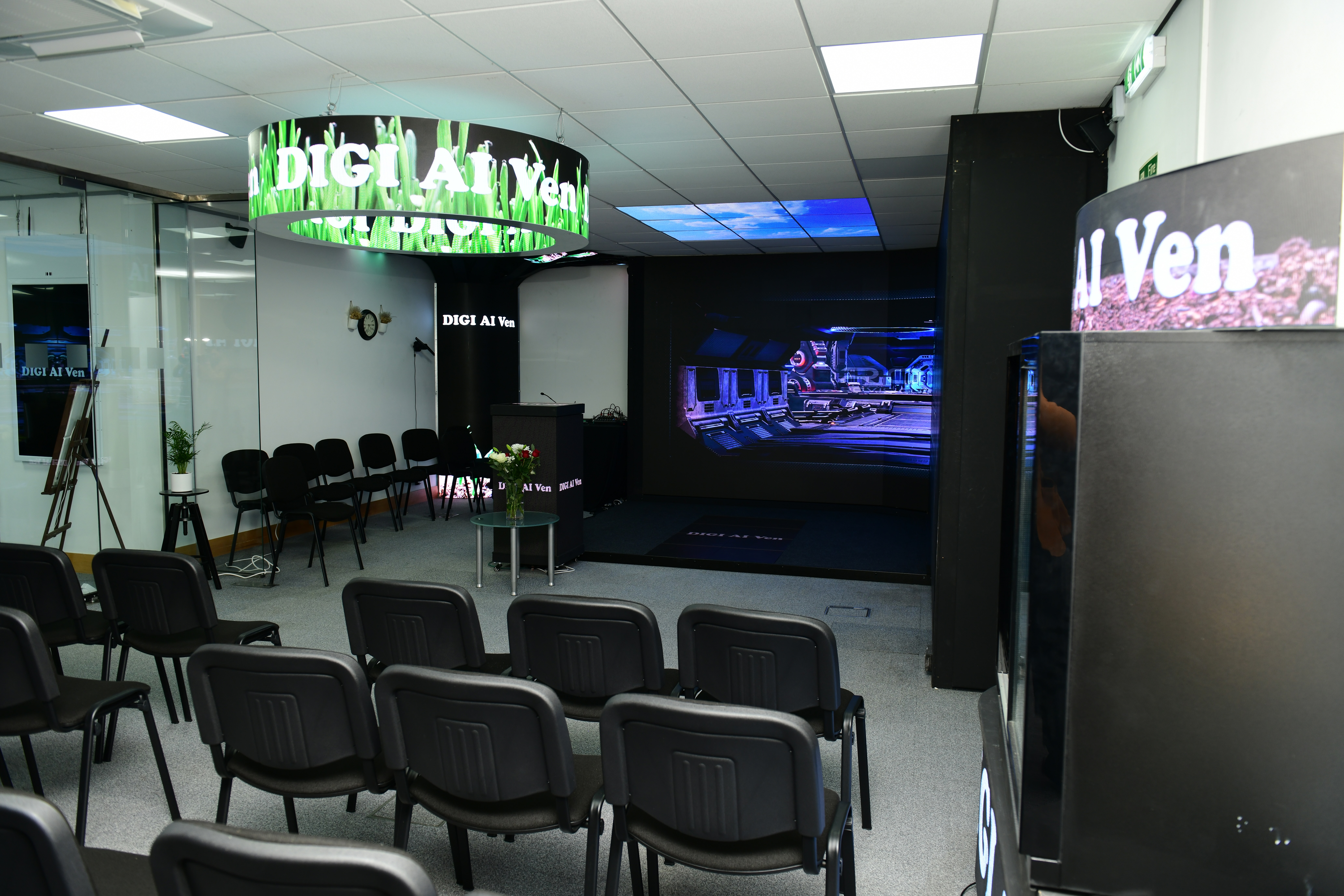 Modern conference room with black chairs and large screen for corporate events.