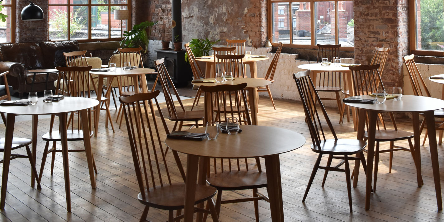Versatile bakery event space with wooden tables, ideal for meetings and receptions.