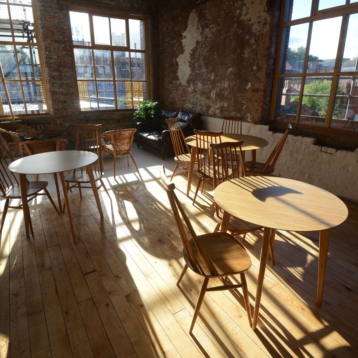 Bright bakery event space with wooden tables, ideal for creative meetings and workshops.