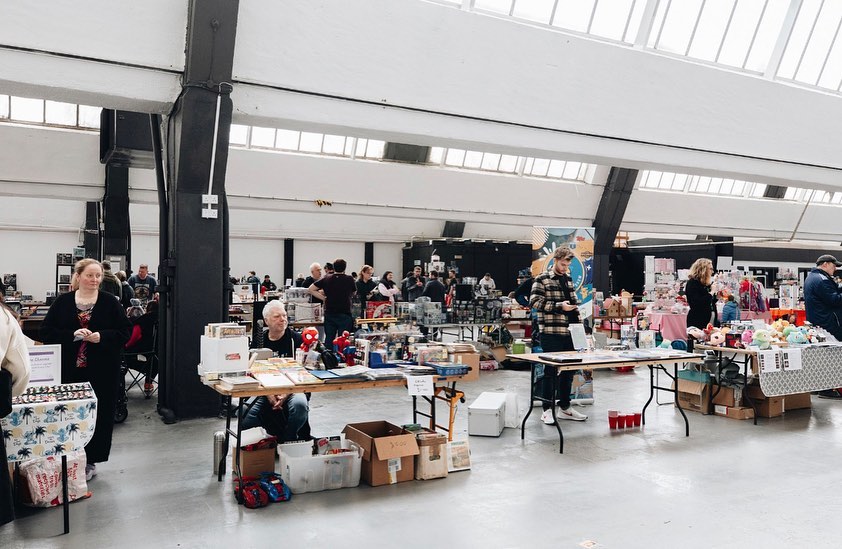 "Box Hub Warehouse trade show with vendors, open layout, and vibrant atmosphere."