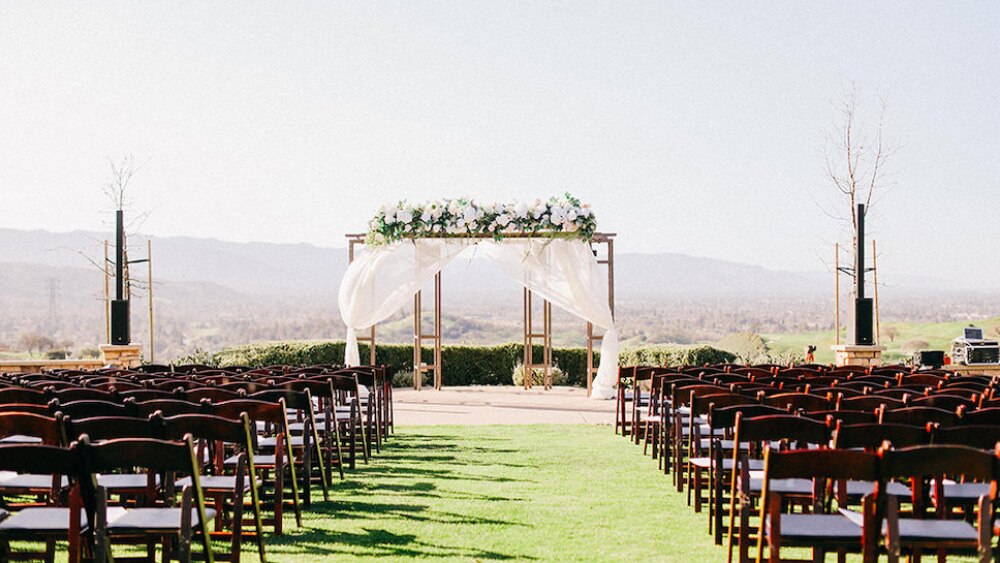 Outdoor wedding ceremony space with floral arch at Americas Best Value Inn, San Jose.