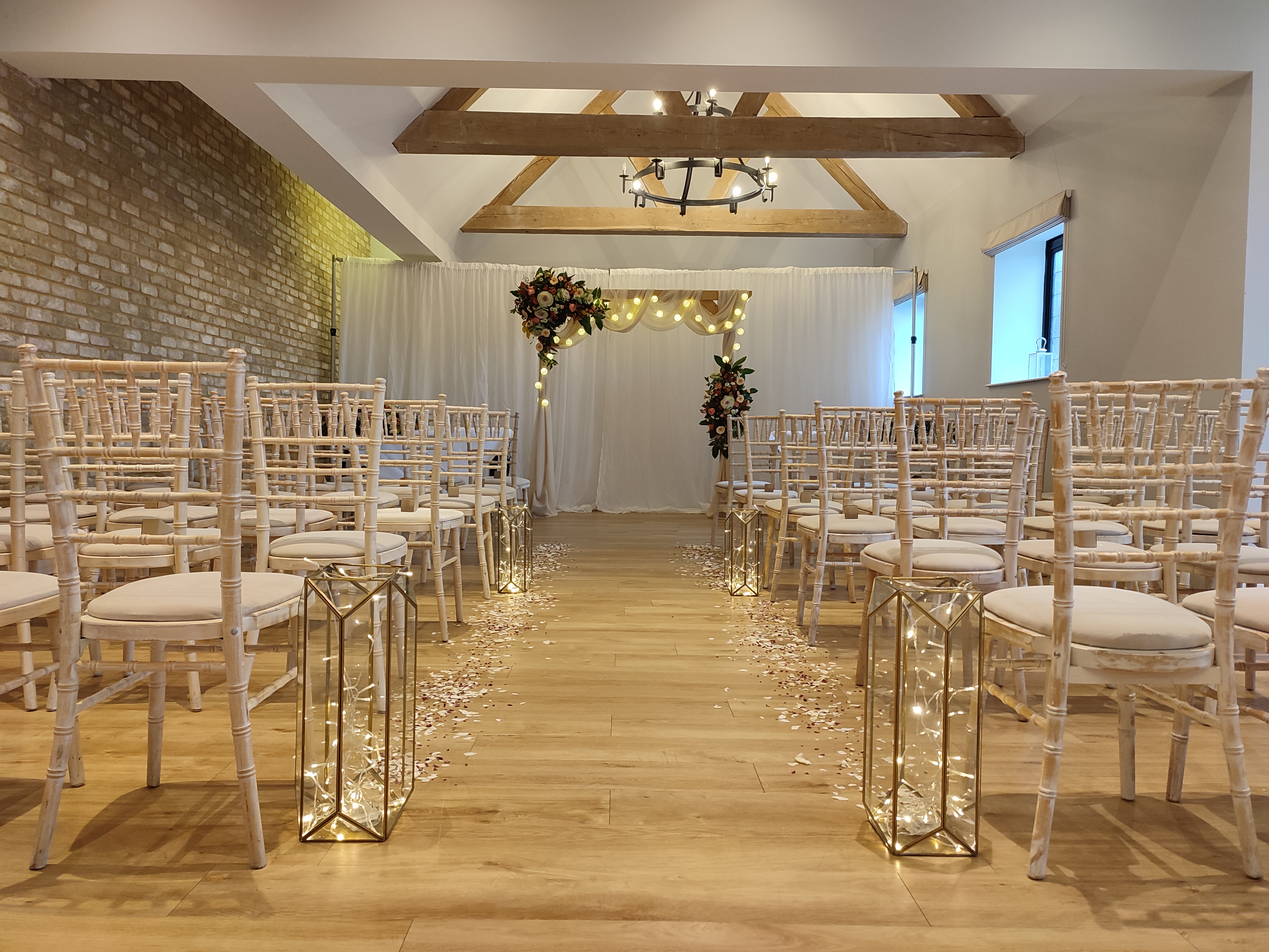 Cedar Suite at Voco Lythe Hill: elegant wedding venue with floral arch and chiavari chairs.