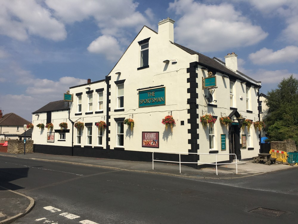 Charming Sportsman Pub exterior with floral decor, ideal for casual meetings and events.