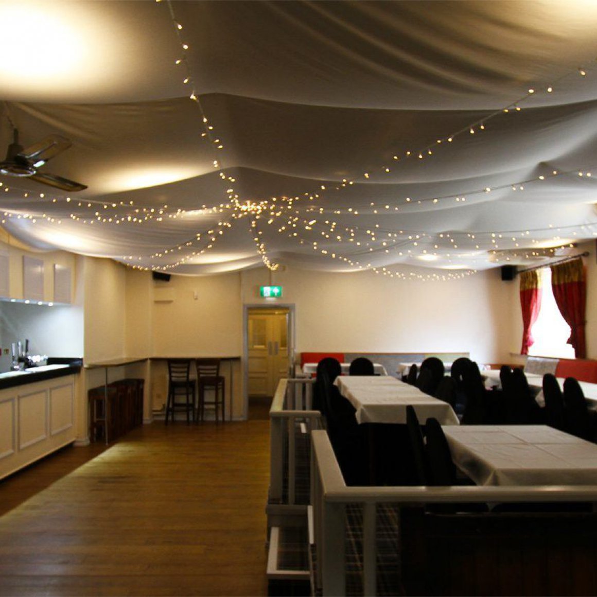 Elegant event space in The Sportsman Pub with long tables and warm lighting.