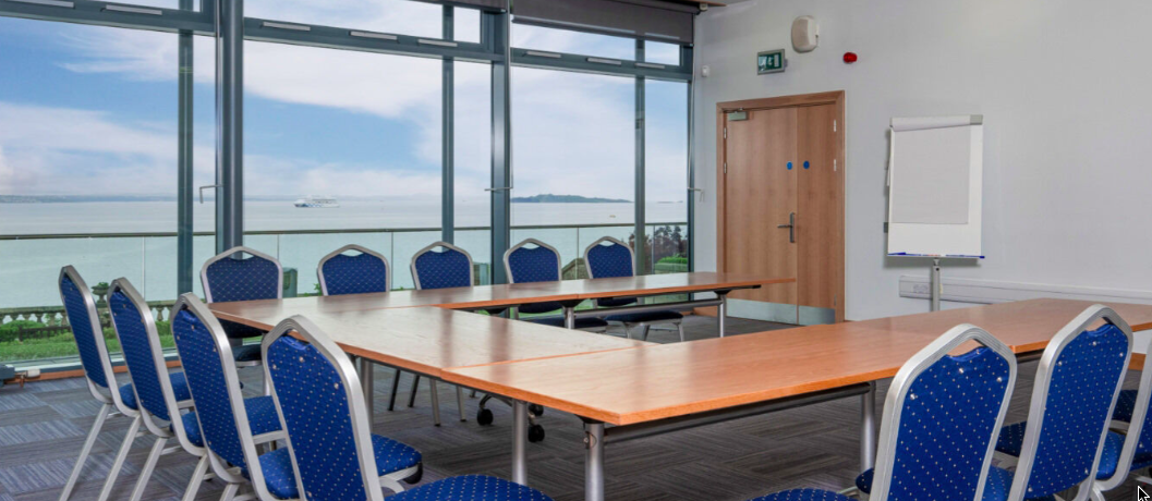 Meeting room in Fidra N°17 with blue chairs and scenic windows for brainstorming sessions.