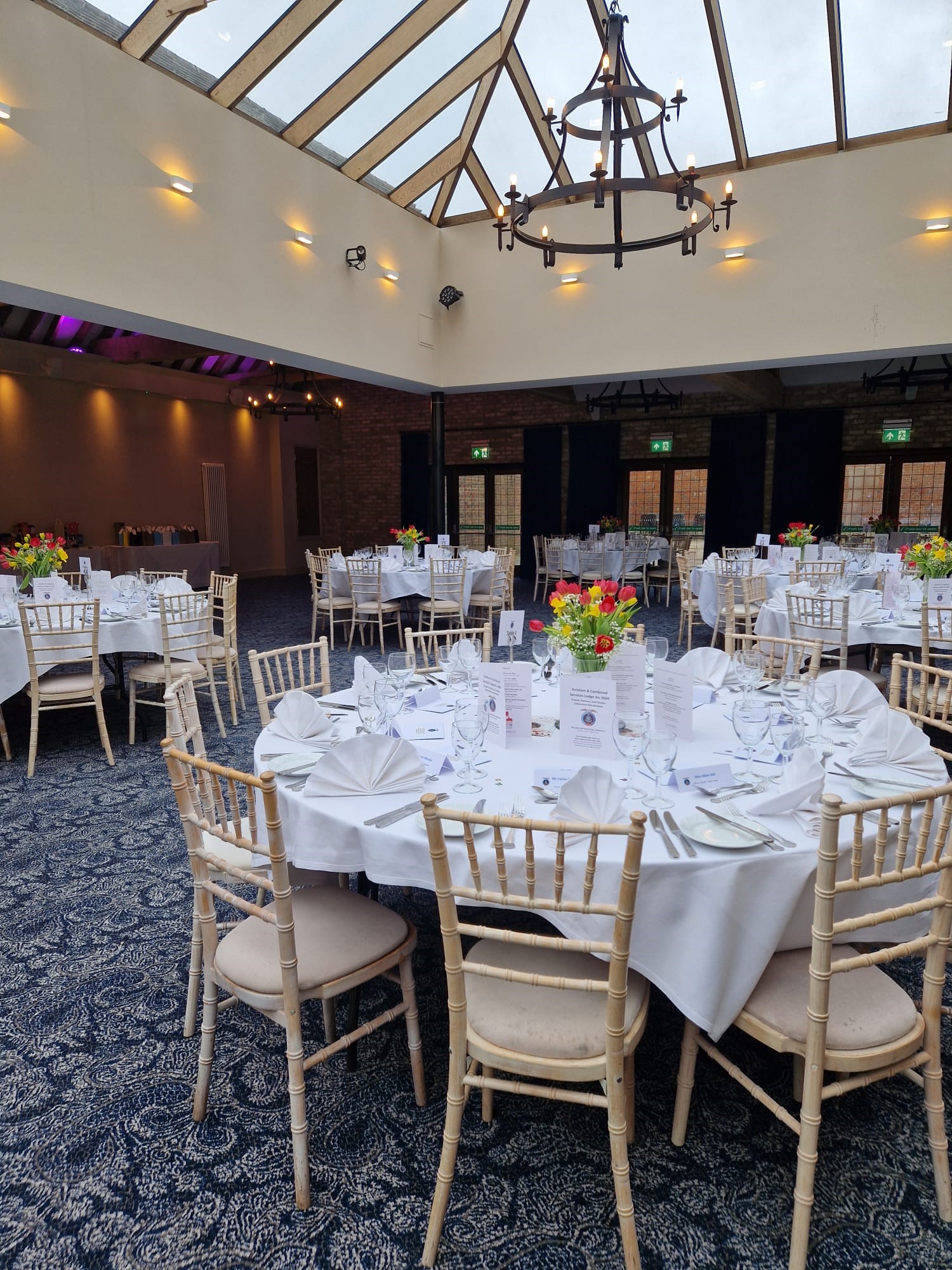 Hazel Suite at Voco Lythe Hill Hotel, elegant event space with floral centerpieces.