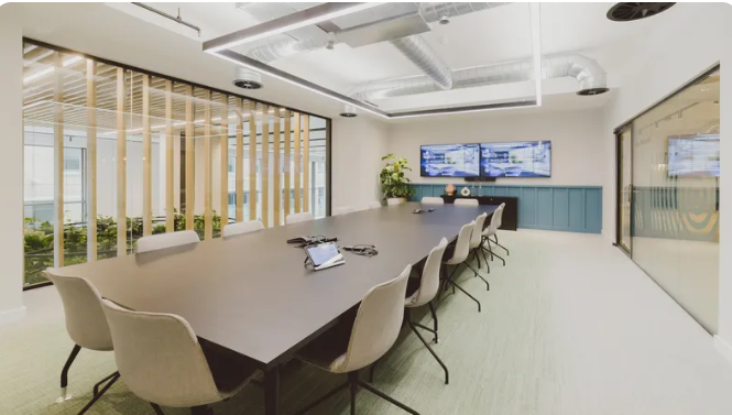 Modern conference room with large table, ideal for meetings and workshops.
