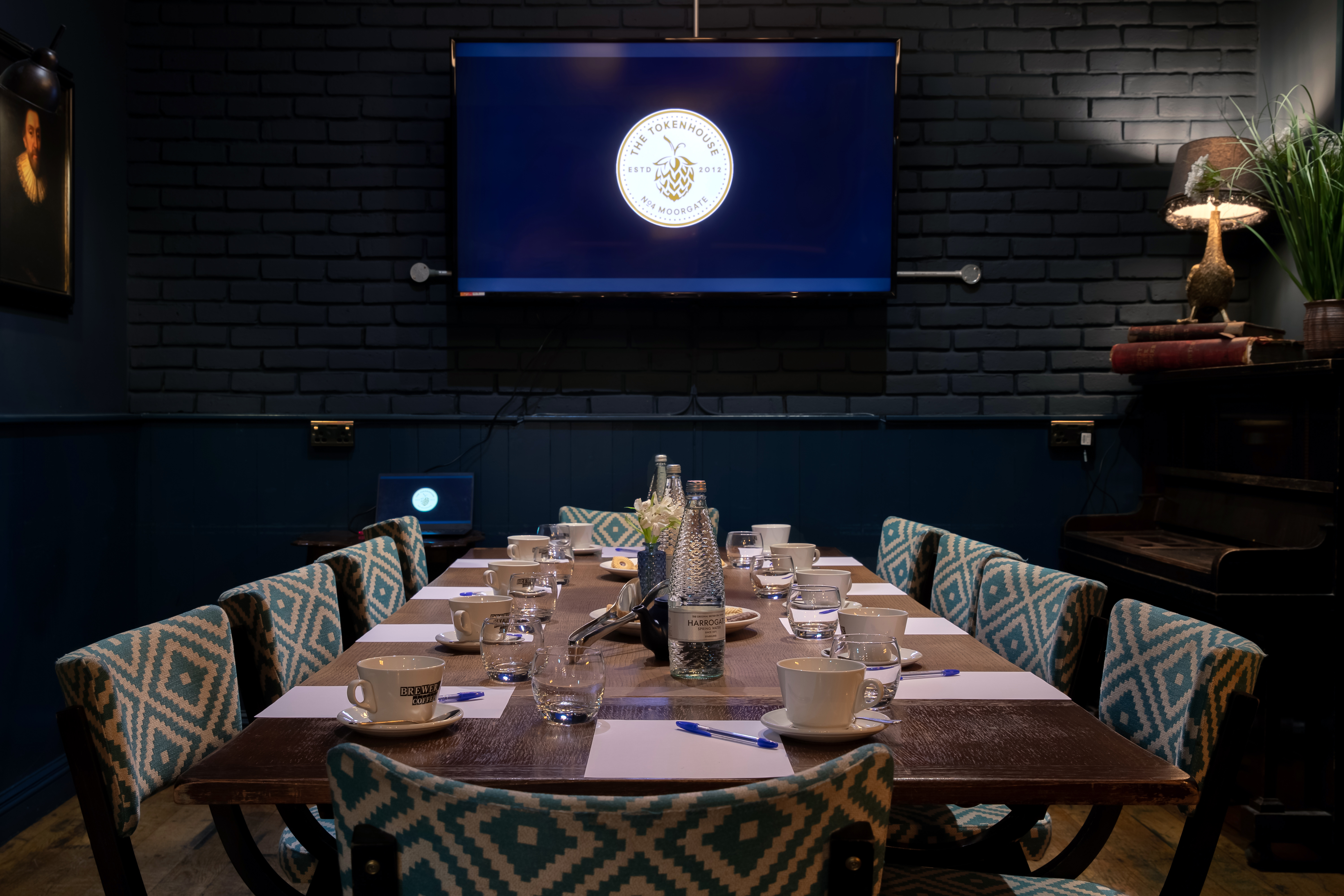 Intimate meeting room with wooden table and large screen at The Tokenhouse.