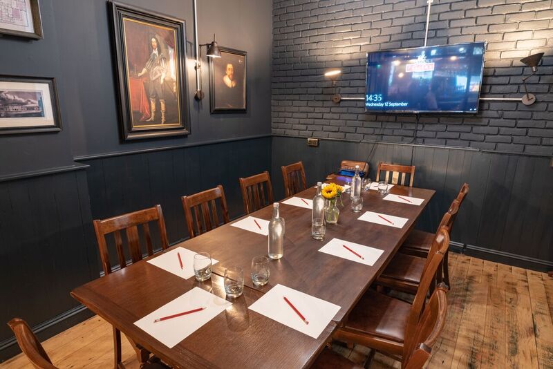 Intimate meeting room with wooden table, ideal for small events and discussions.