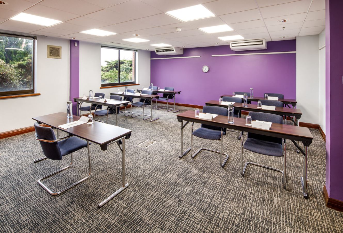 Wenlock Suite meeting room with purple accent wall, ideal for workshops and training.