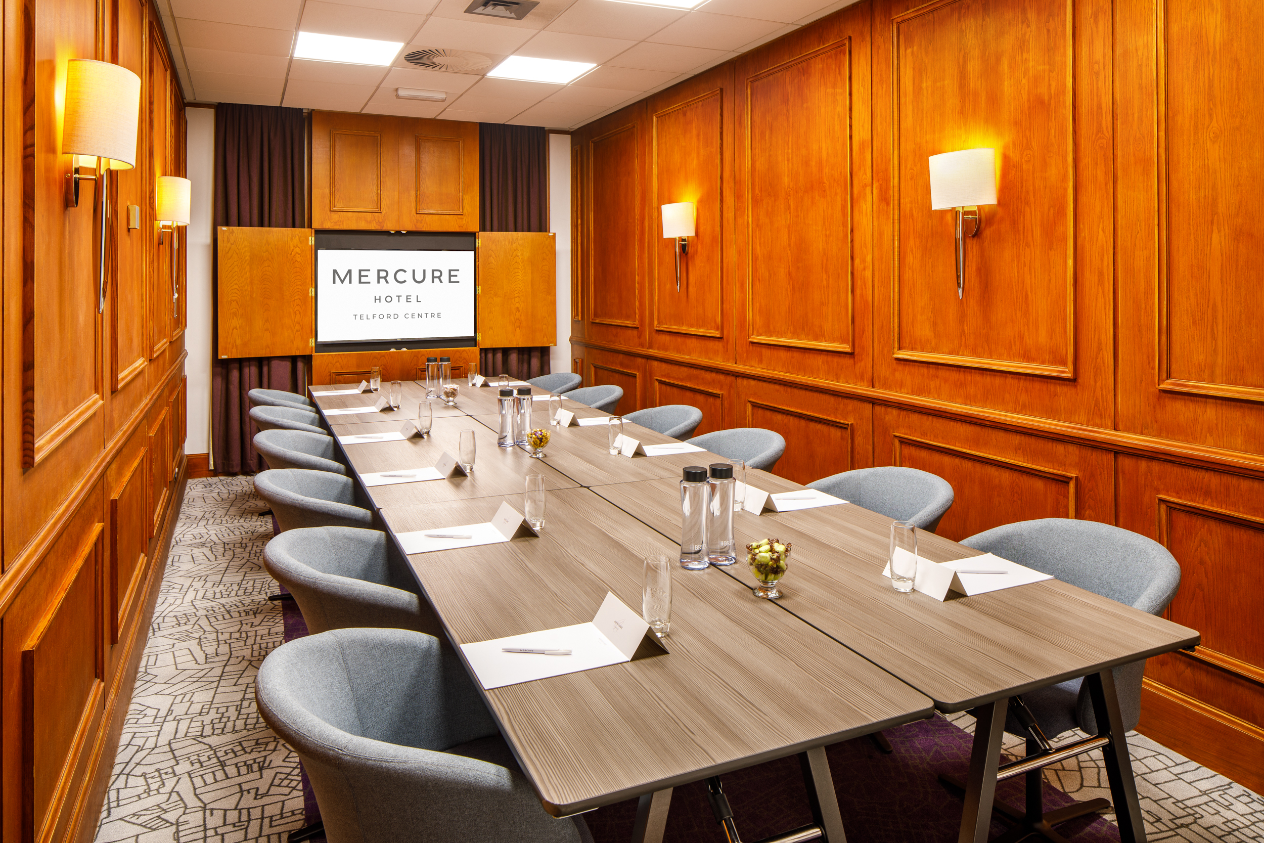 Shifnal Suite meeting room with wooden paneling, ideal for professional events and presentations.