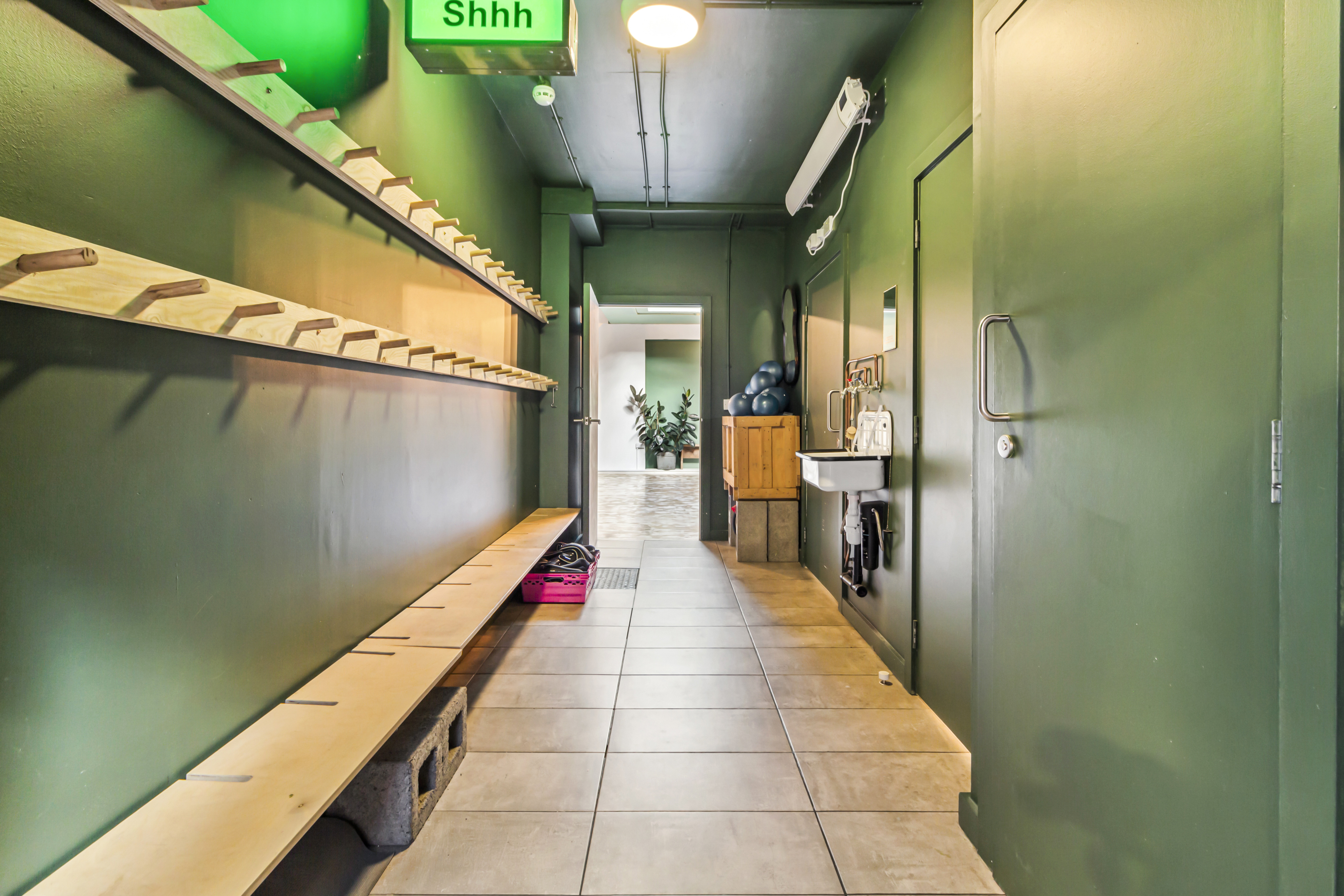 Yoga studio hallway with green walls, ideal for events and mingling.