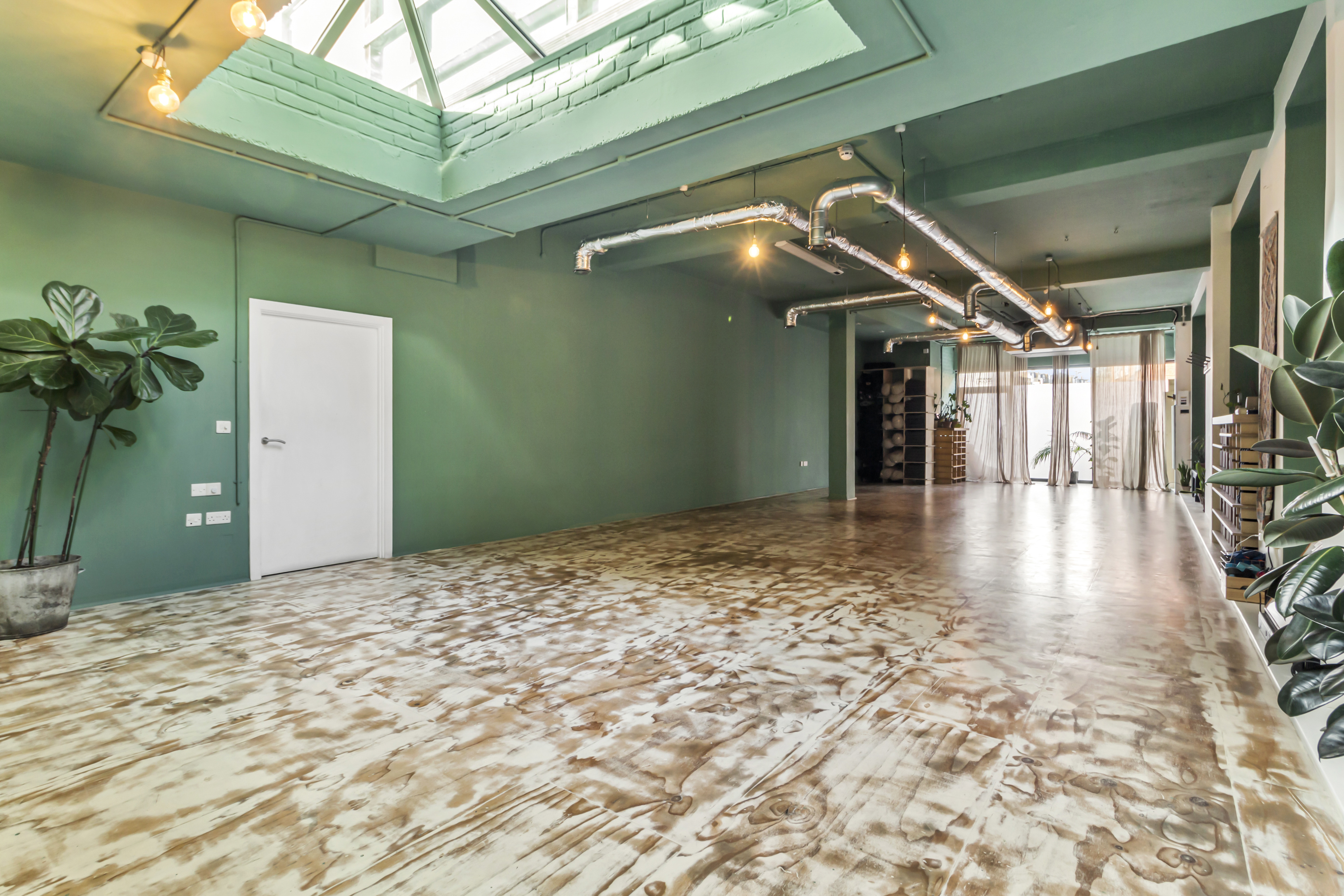 Modern yoga studio with green walls, perfect for workshops and events.