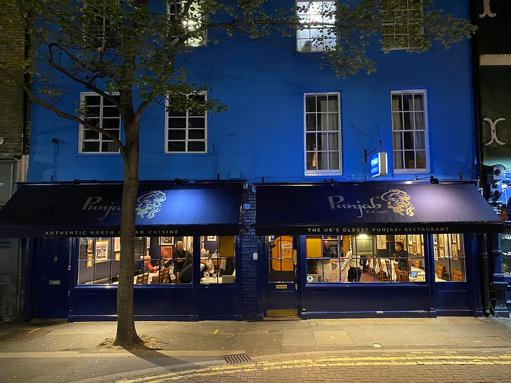 "Vibrant Punjab Restaurant exterior with blue facade, ideal for gatherings and events."