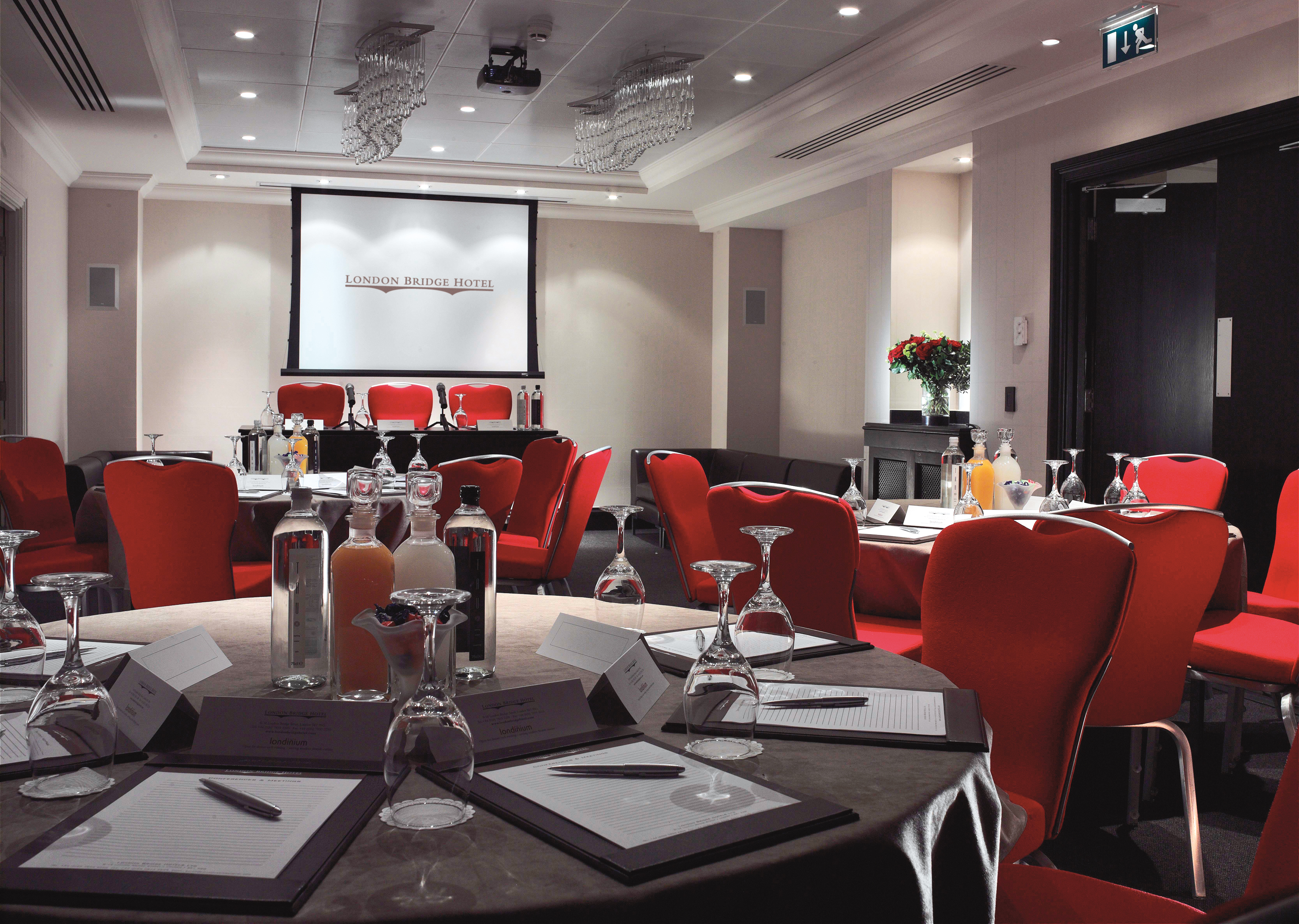 Shakespeare Suite meeting room with round tables, red chairs for corporate events in London.