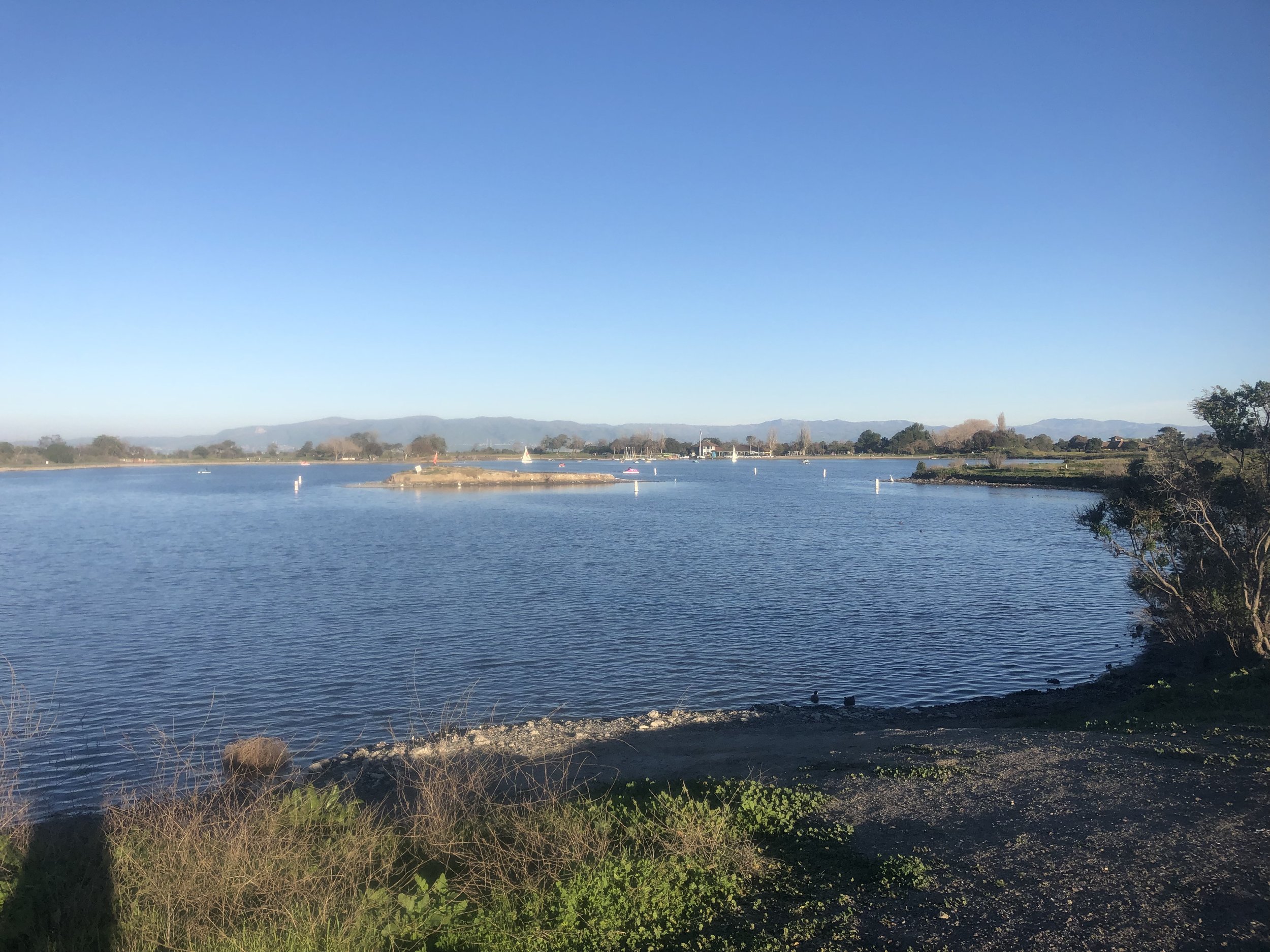 Serene Shoreline Lake venue with calm water, ideal for outdoor events and retreats.