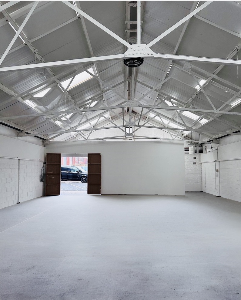 Versatile open event space with high ceilings, ideal for meetings and workshops.