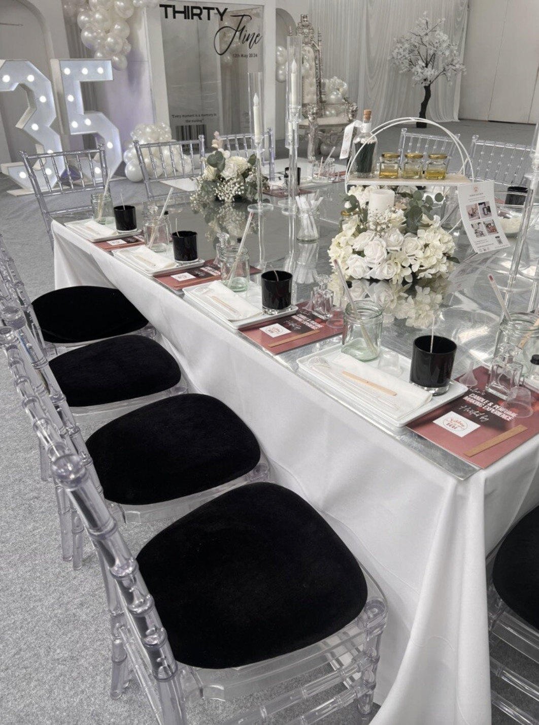 Elegant event table with black seating and floral centerpiece for corporate gatherings.