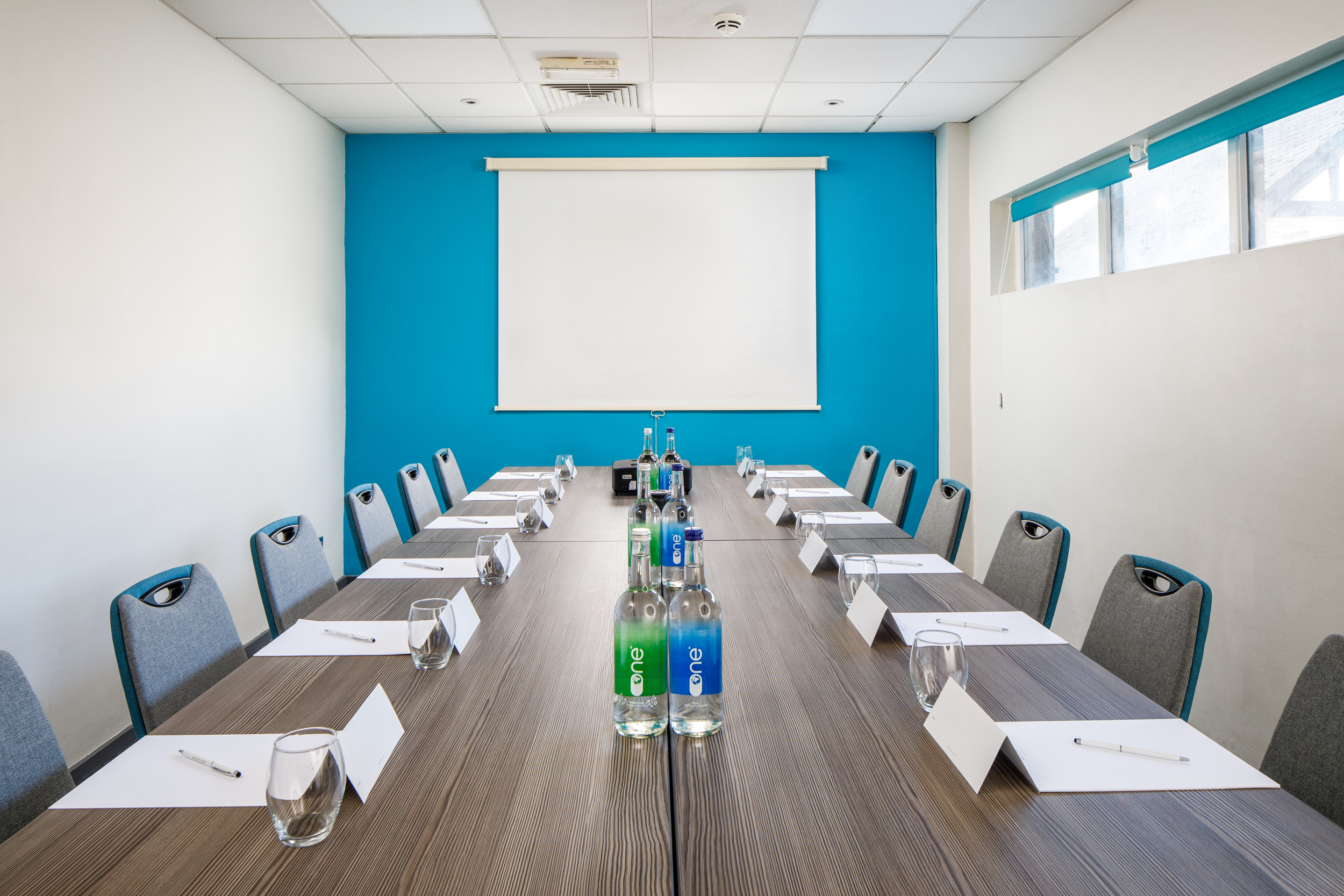 Meeting room at Mercure Bedford with blue accent wall, ideal for professional events.