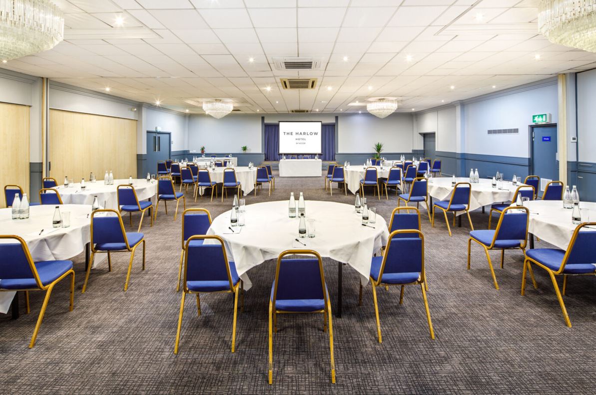 Buckinghamshire Suite at Harlow Hotel, corporate meeting space with round tables and projector.