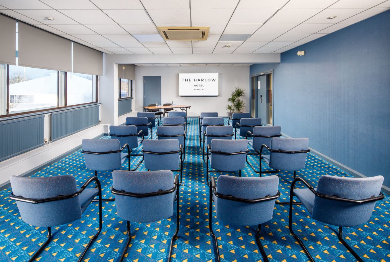 "Essex Harlow Hotel meeting room with blue decor, perfect for corporate workshops."