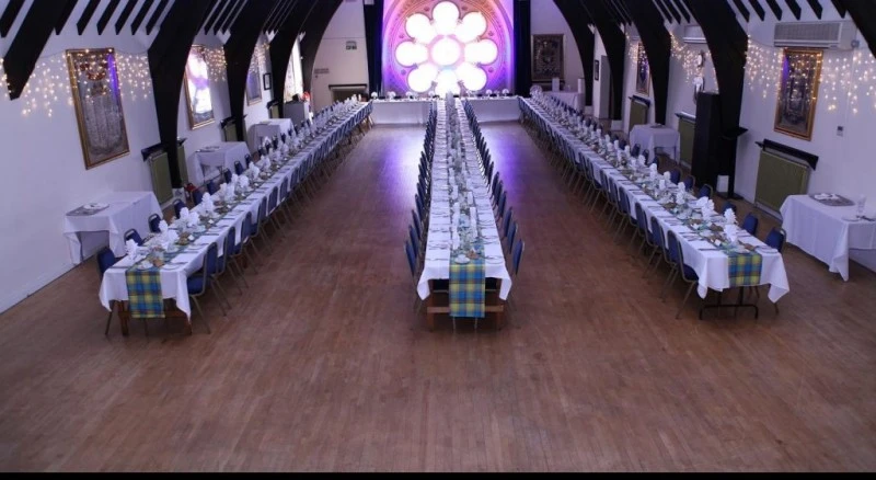 Elegant banquet hall with long table setup for formal events and celebrations.