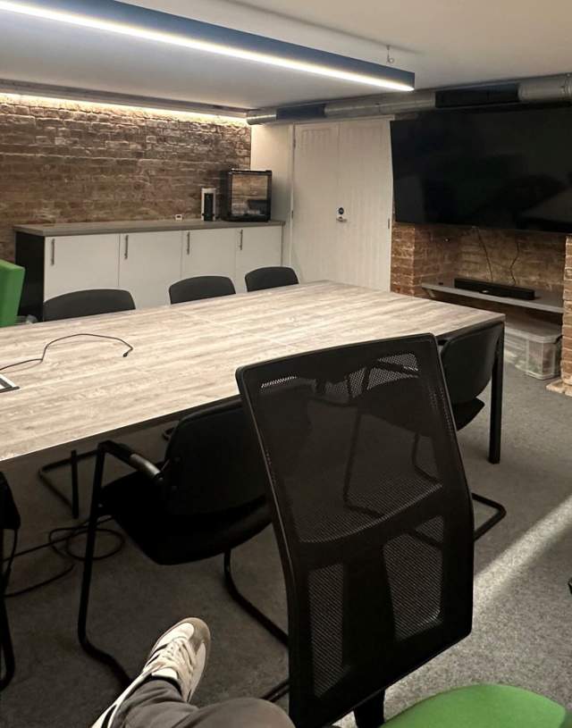 Modern meeting room with wooden table, ideal for presentations and brainstorming.