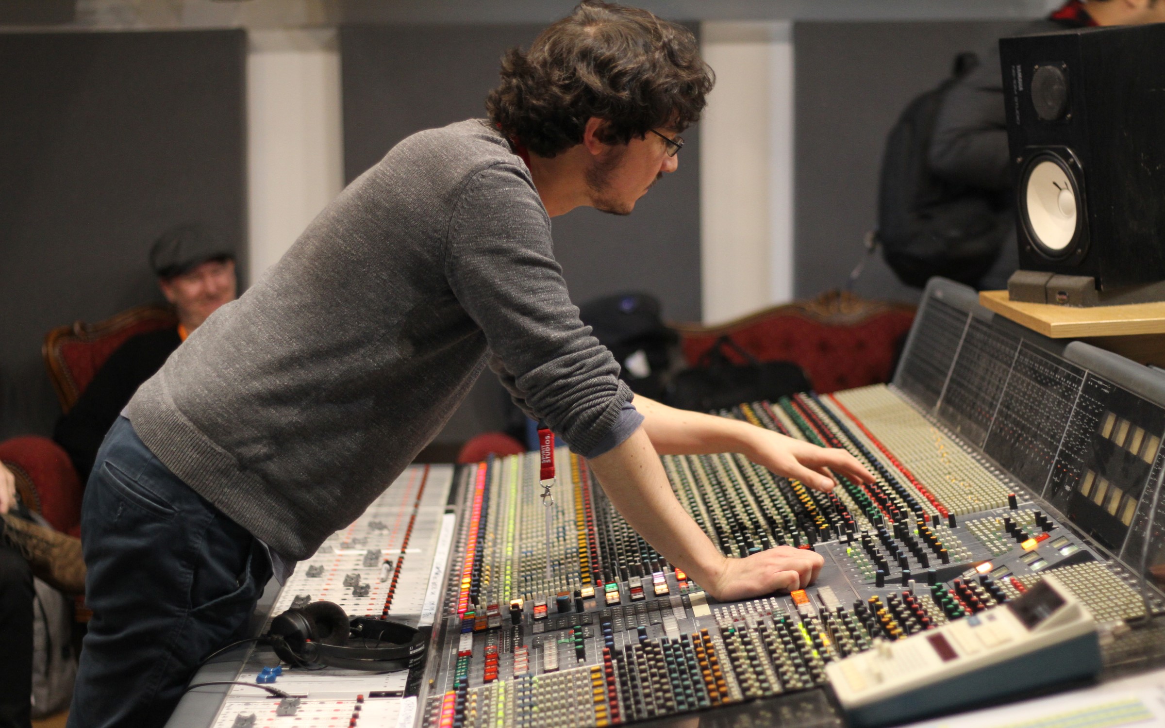 Sound engineer adjusting mixing console in Z-arts music studio for quality event audio.