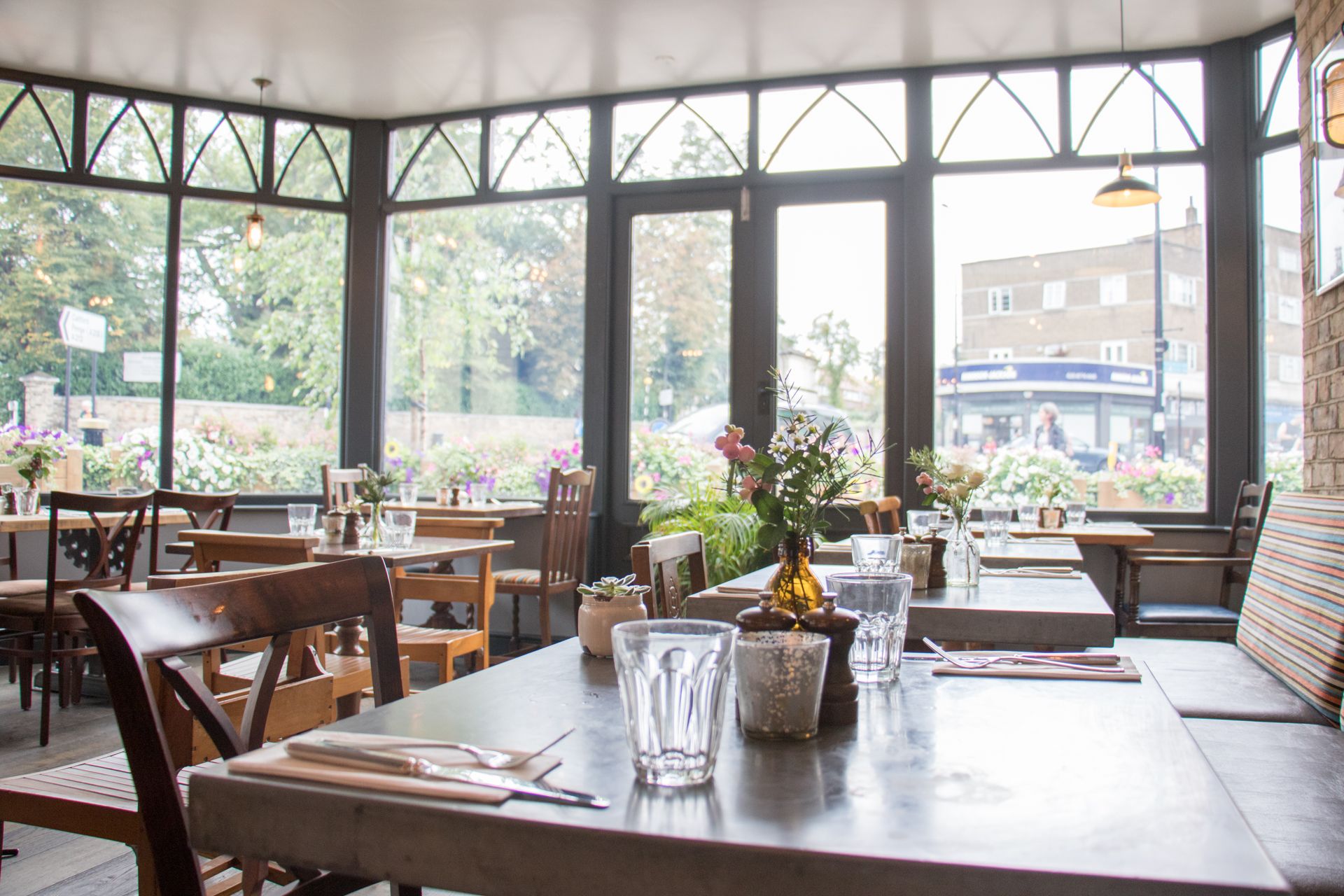 Bright dining space at The Greyhound for events, featuring natural light and floral decor.