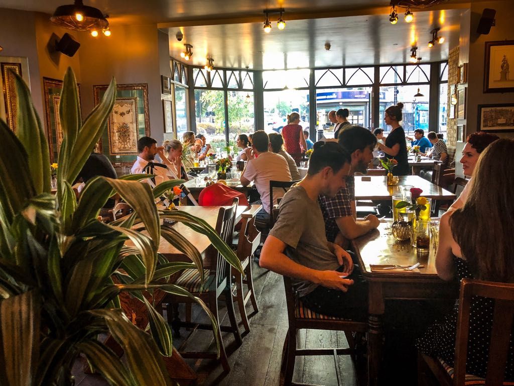 Vibrant restaurant venue hire with greenery for casual meetings and networking events.