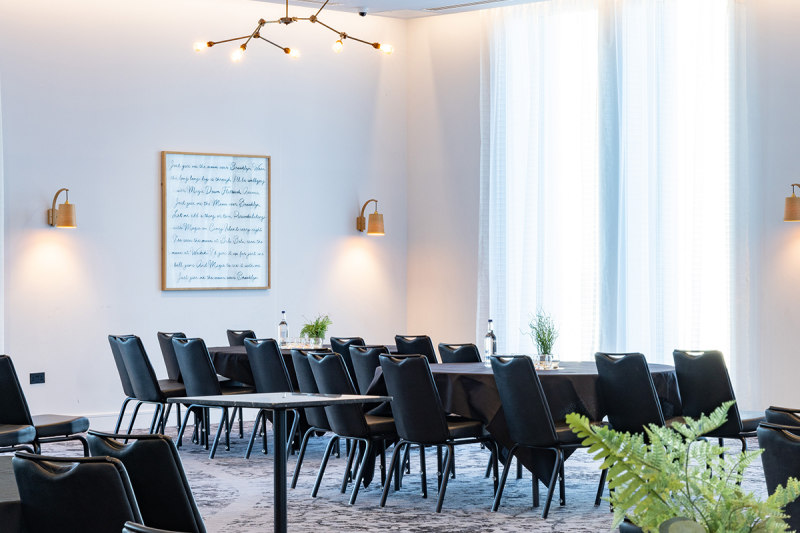 Modern meeting room in voco Manchester, featuring natural light and sleek design for corporate events.