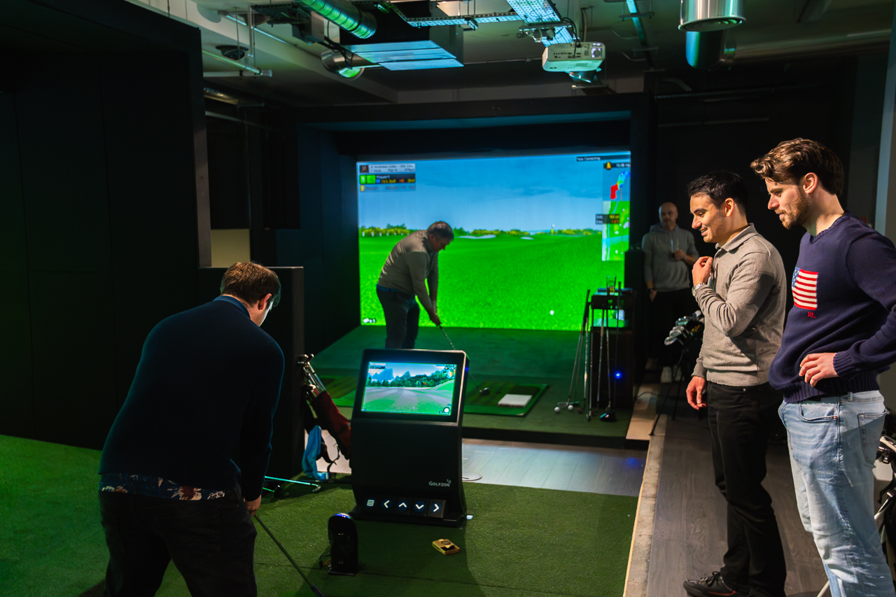 Indoor golf simulator setup for corporate team-building and networking events.