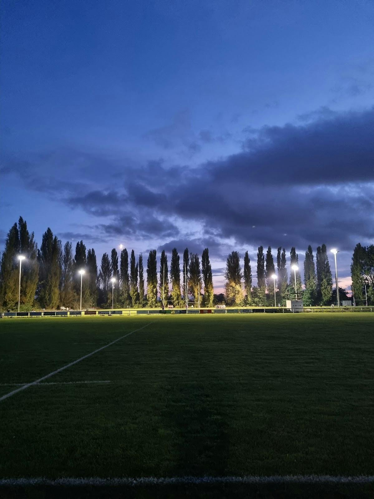 Well-lit Staines Rugby Club field at dusk, perfect for outdoor events and sports gatherings.