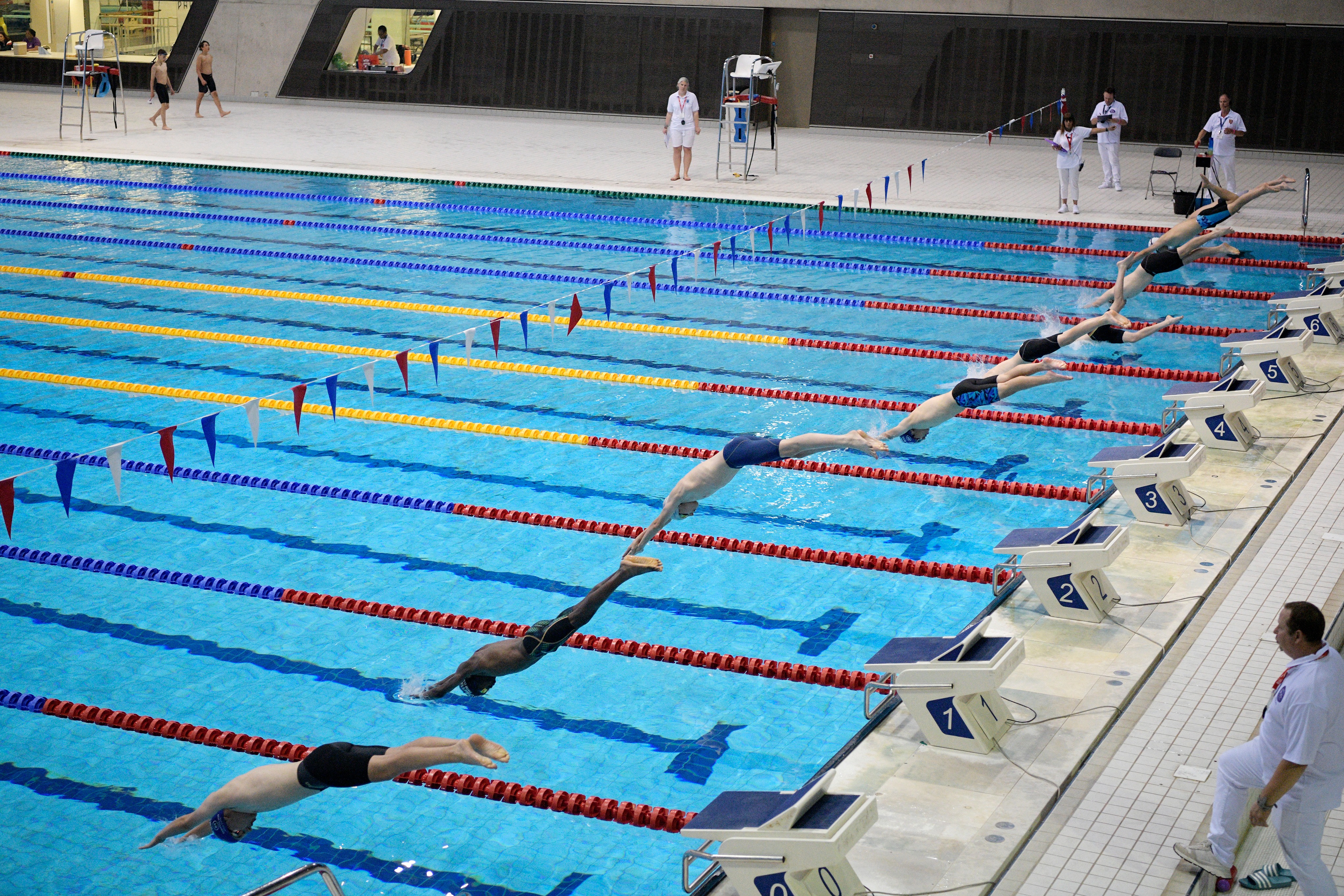 Dynamic swimming competition at London Aquatics Centre, showcasing athlete dives and engagement.