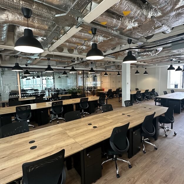 Modern meeting room with wooden tables for rent in Manchester business center.