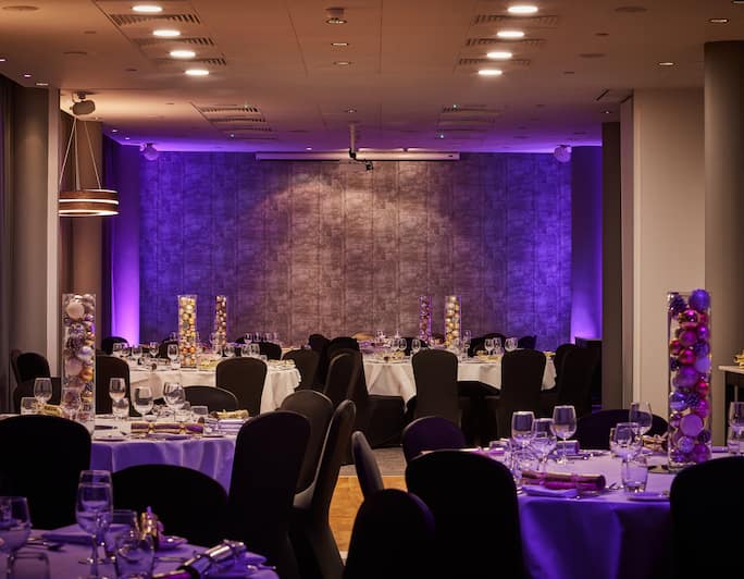 Elegant meeting room at DoubleTree Manchester with round tables, perfect for weddings.