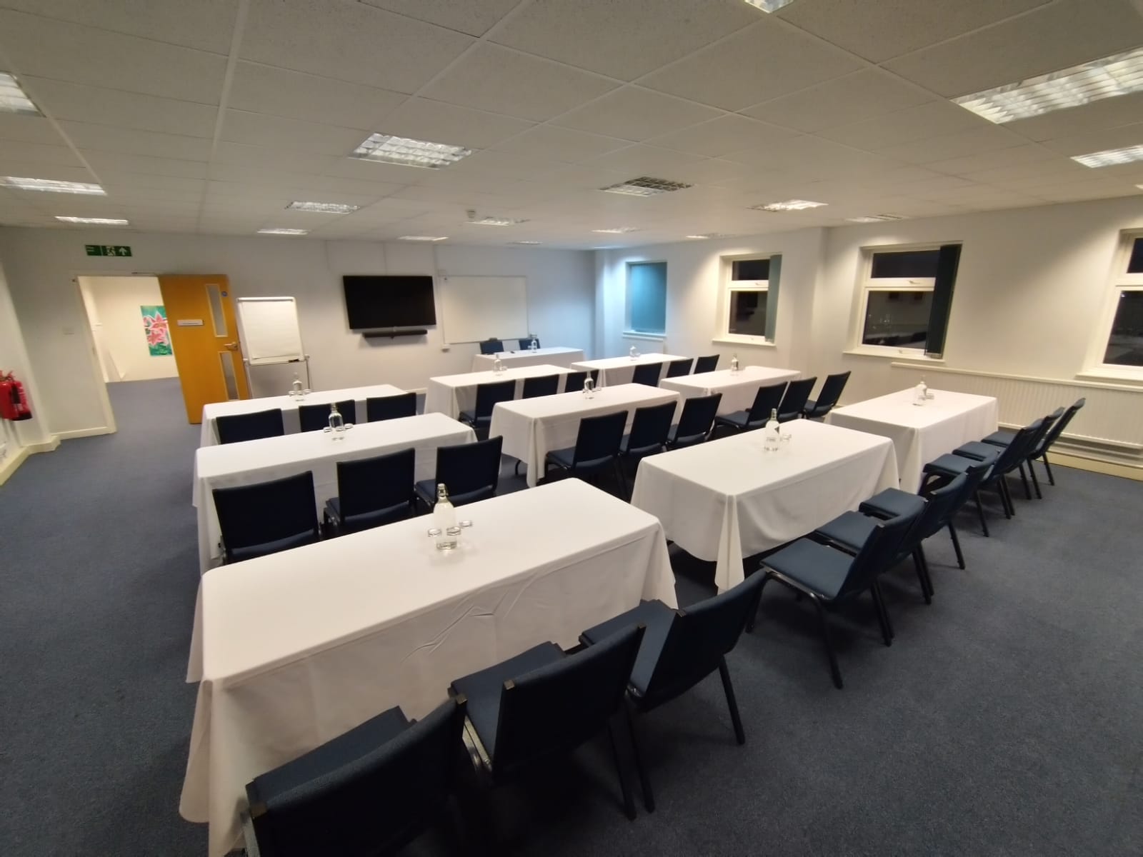 Hinksey Room at The King's Centre, Oxford: professional meeting space with tables and screen.