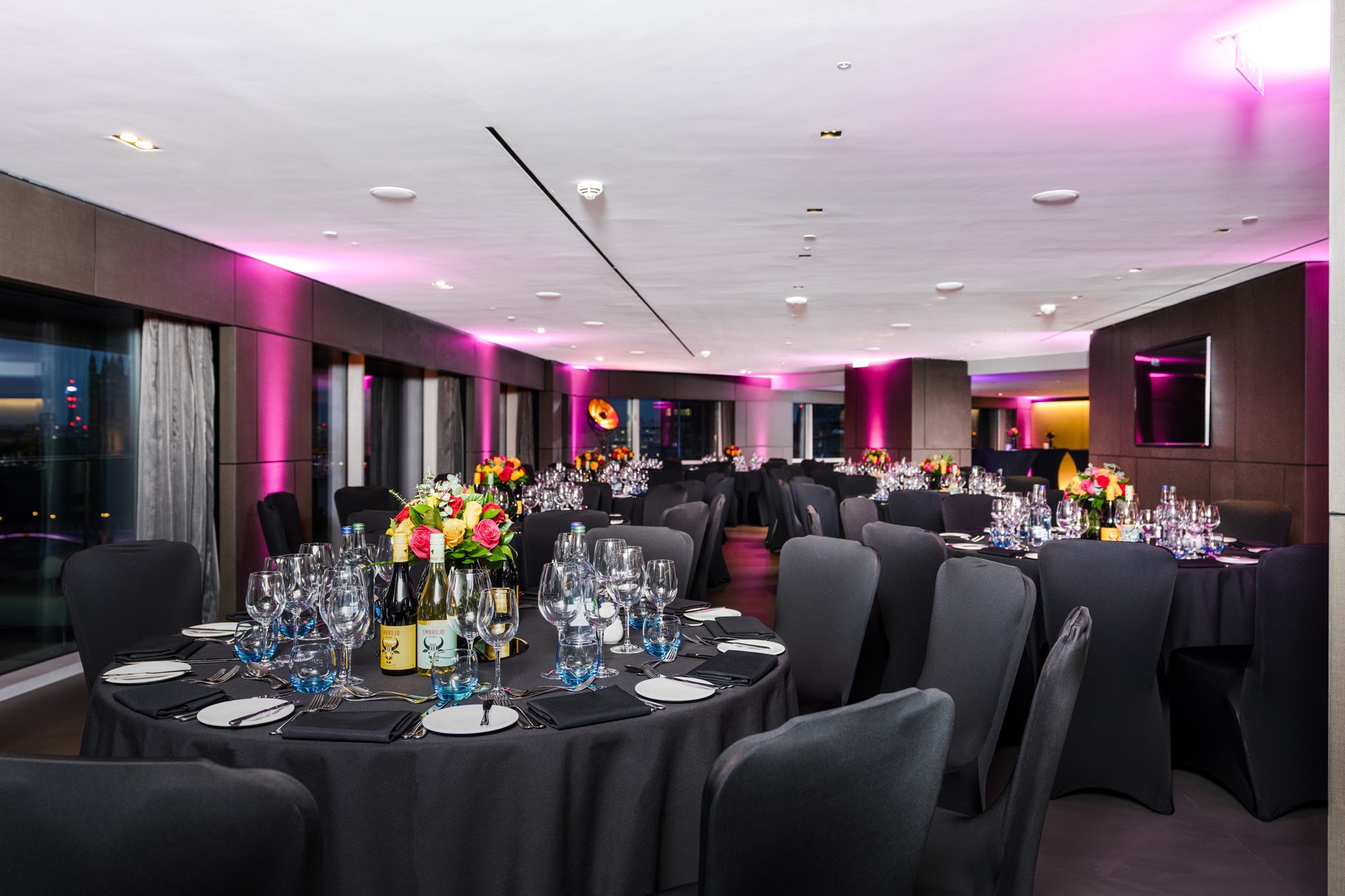 Riverview Lounge, elegant dinner setup with floral centerpieces for corporate events.