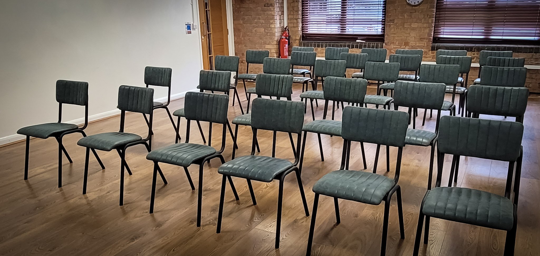 Blue Room setup with rows of chairs for meetings and workshops at Remark! Events.