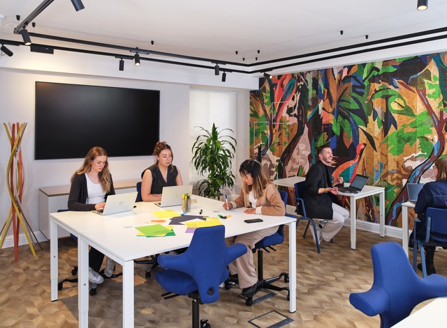 Modern design studio with vibrant mural, ideal for meetings and creative workshops.